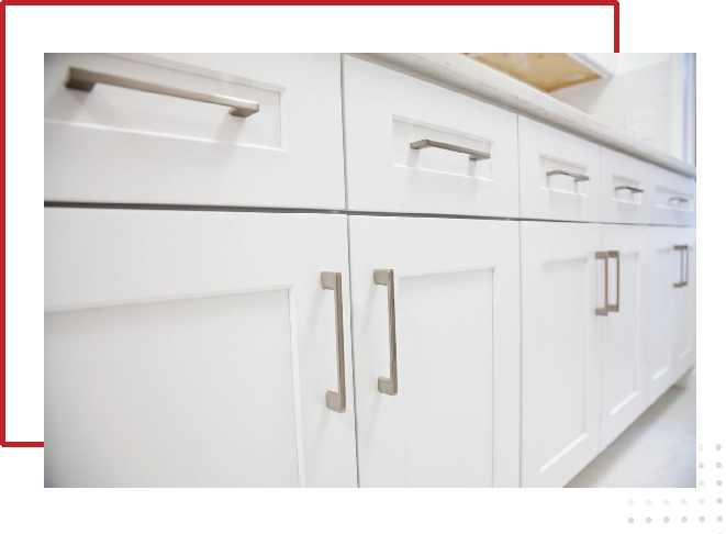 A close up of the handles on white cabinets