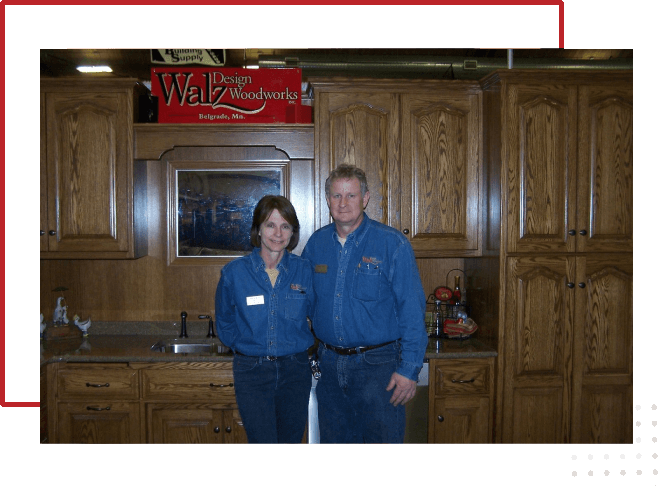 A man and woman standing in front of a kitchen.