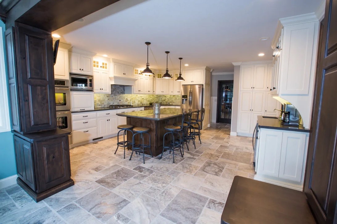 A kitchen with tile floors and white cabinets.