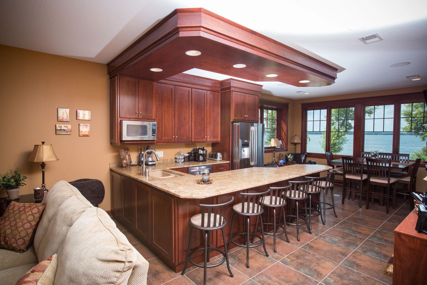 A kitchen with wooden cabinets and brown tile floors.