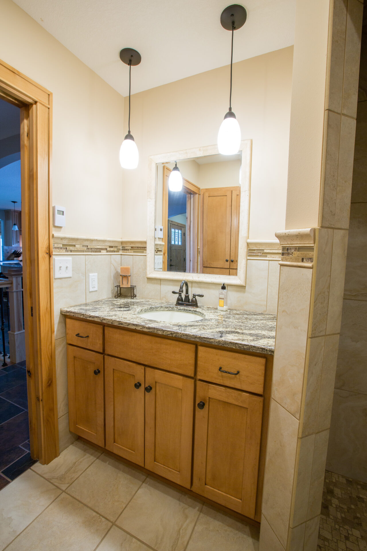 A bathroom with a sink, mirror and lights.