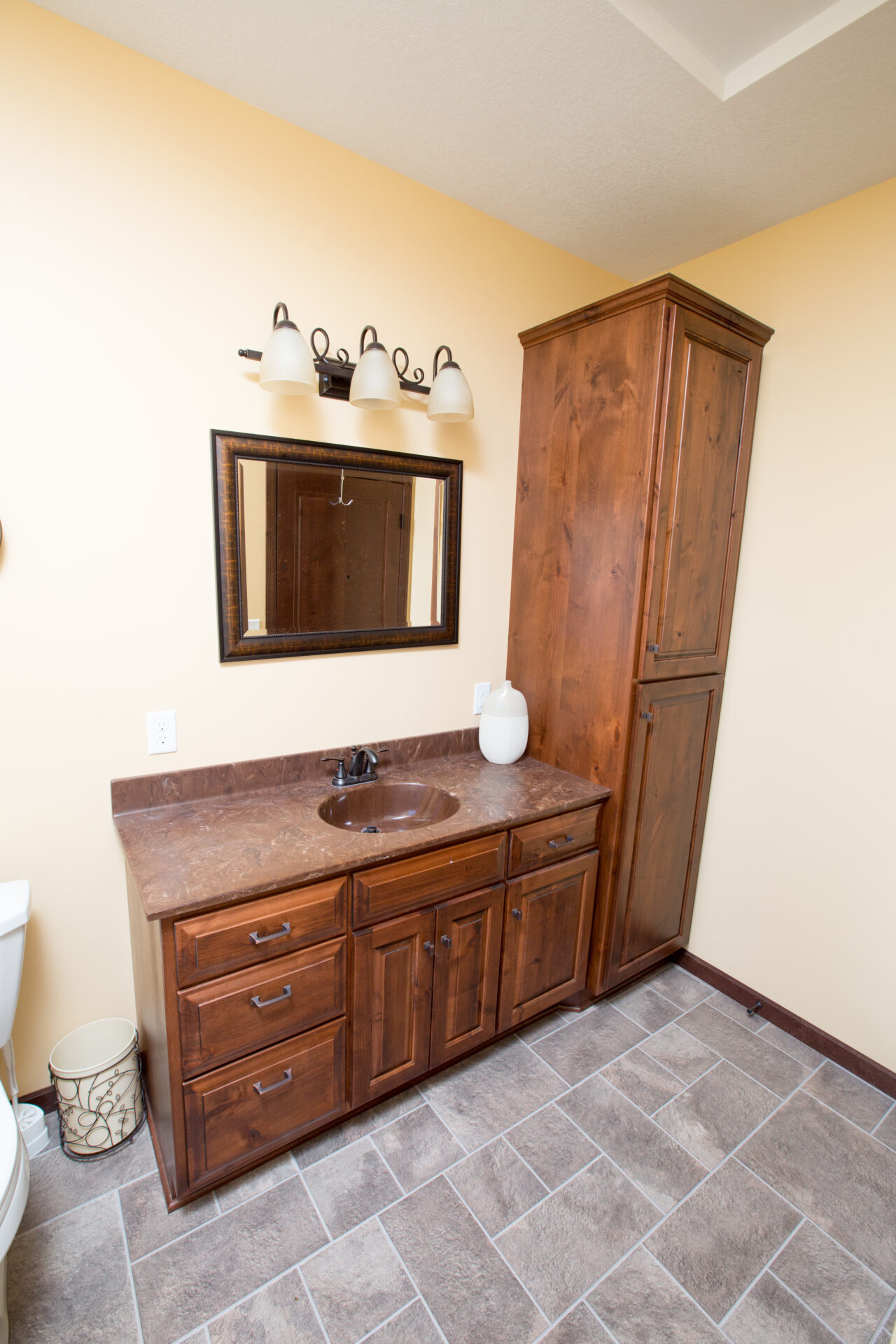 A bathroom with a sink, mirror and cabinet.