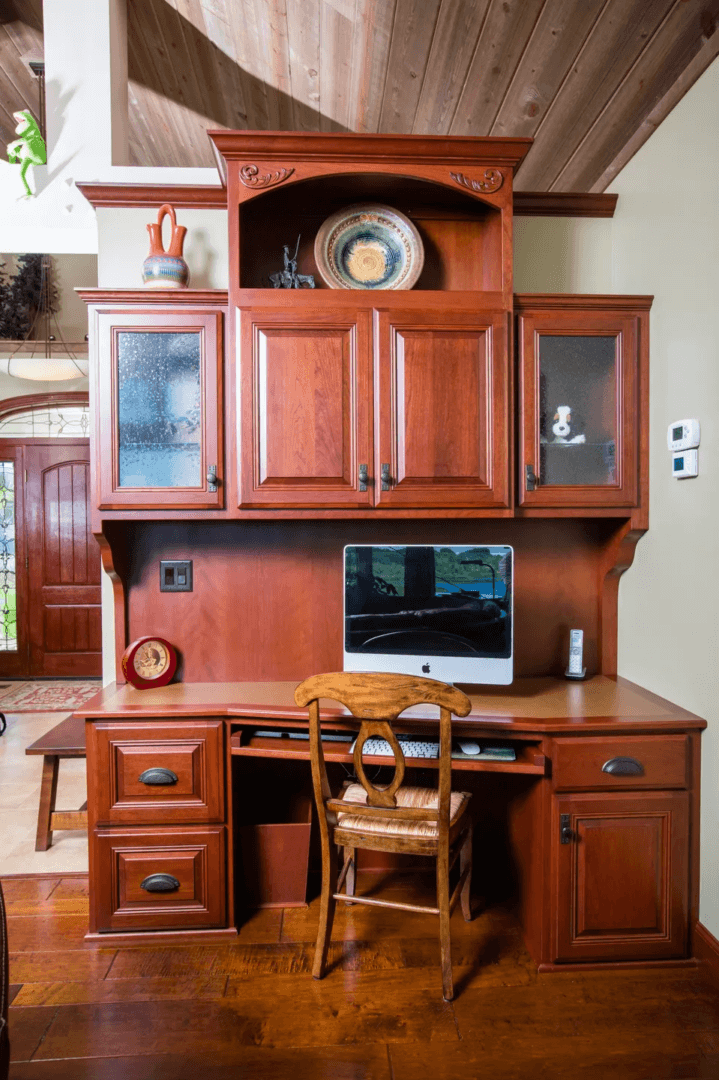 A computer desk with a laptop on top of it.