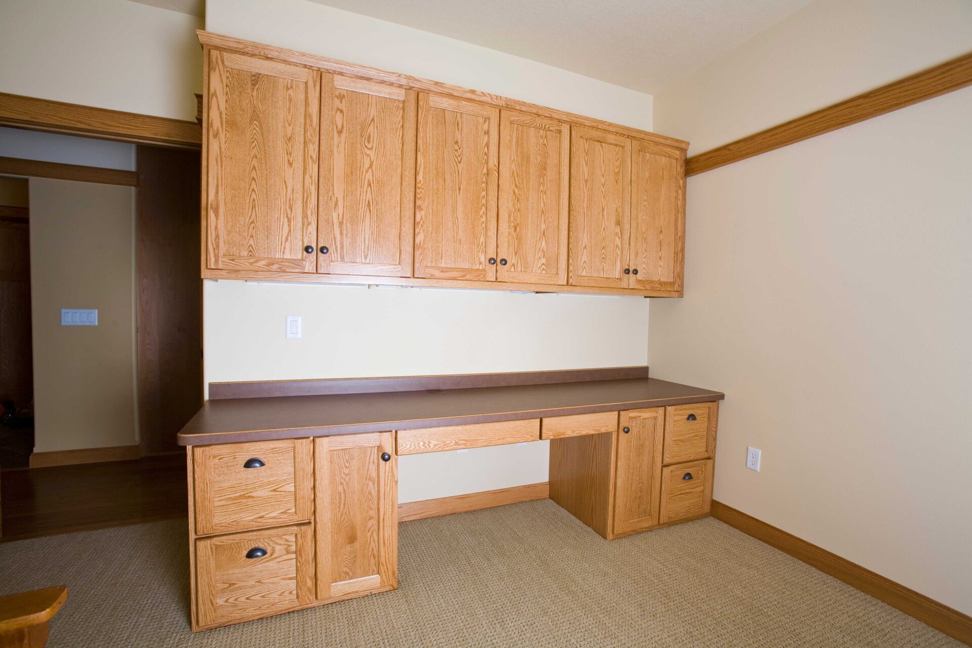 A room with wooden cabinets and a desk.