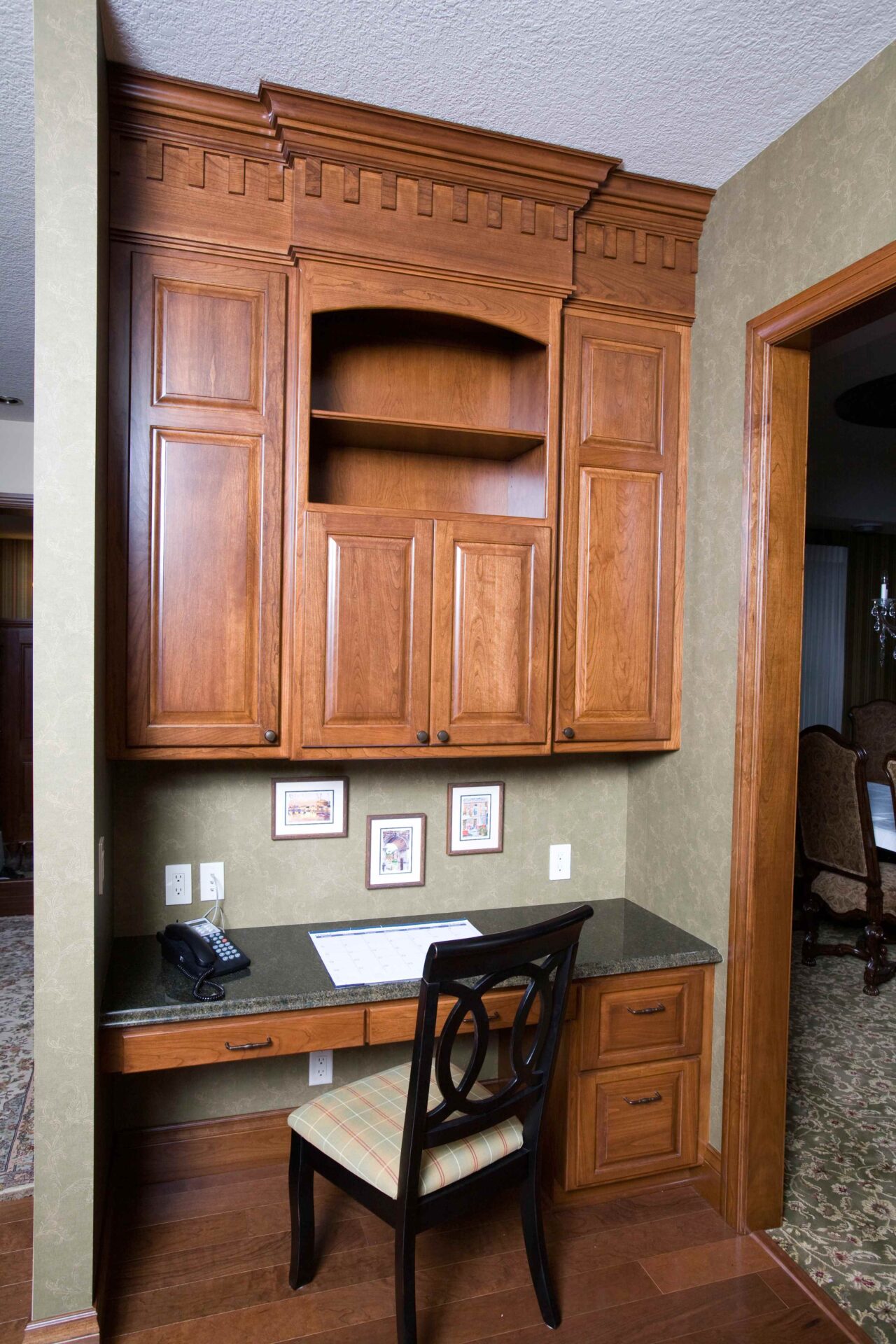 A desk with a chair and some pictures on the wall