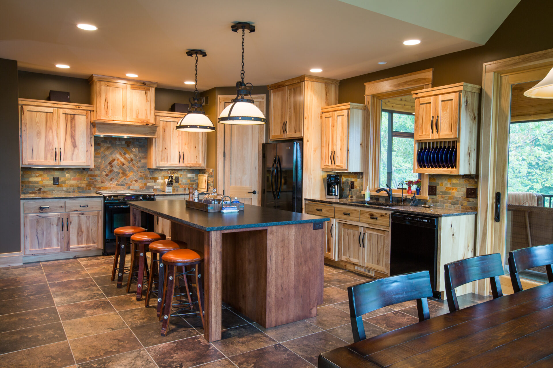 A kitchen with wooden cabinets and black counter tops.