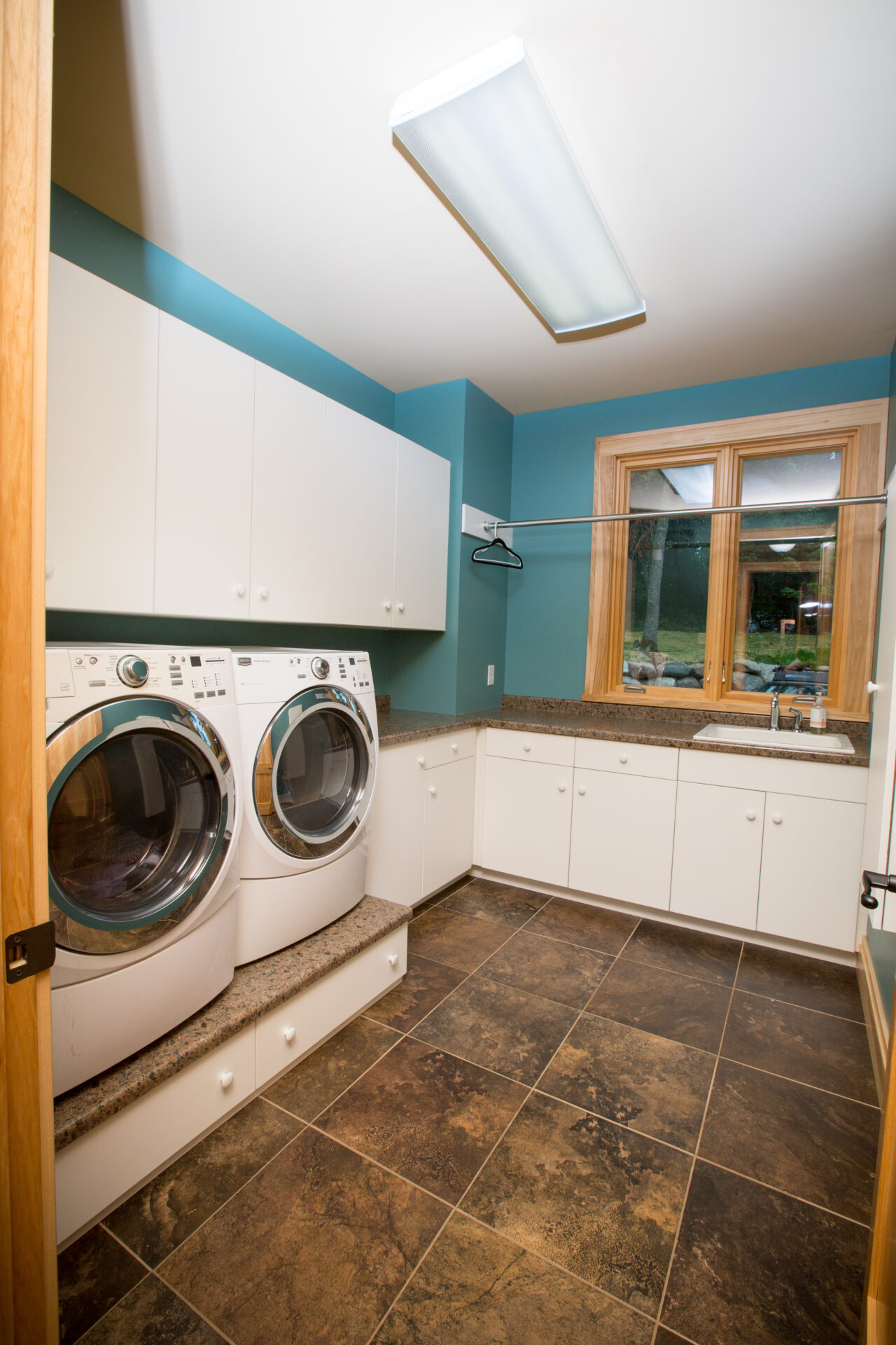 A laundry room with two machines and tile floors.