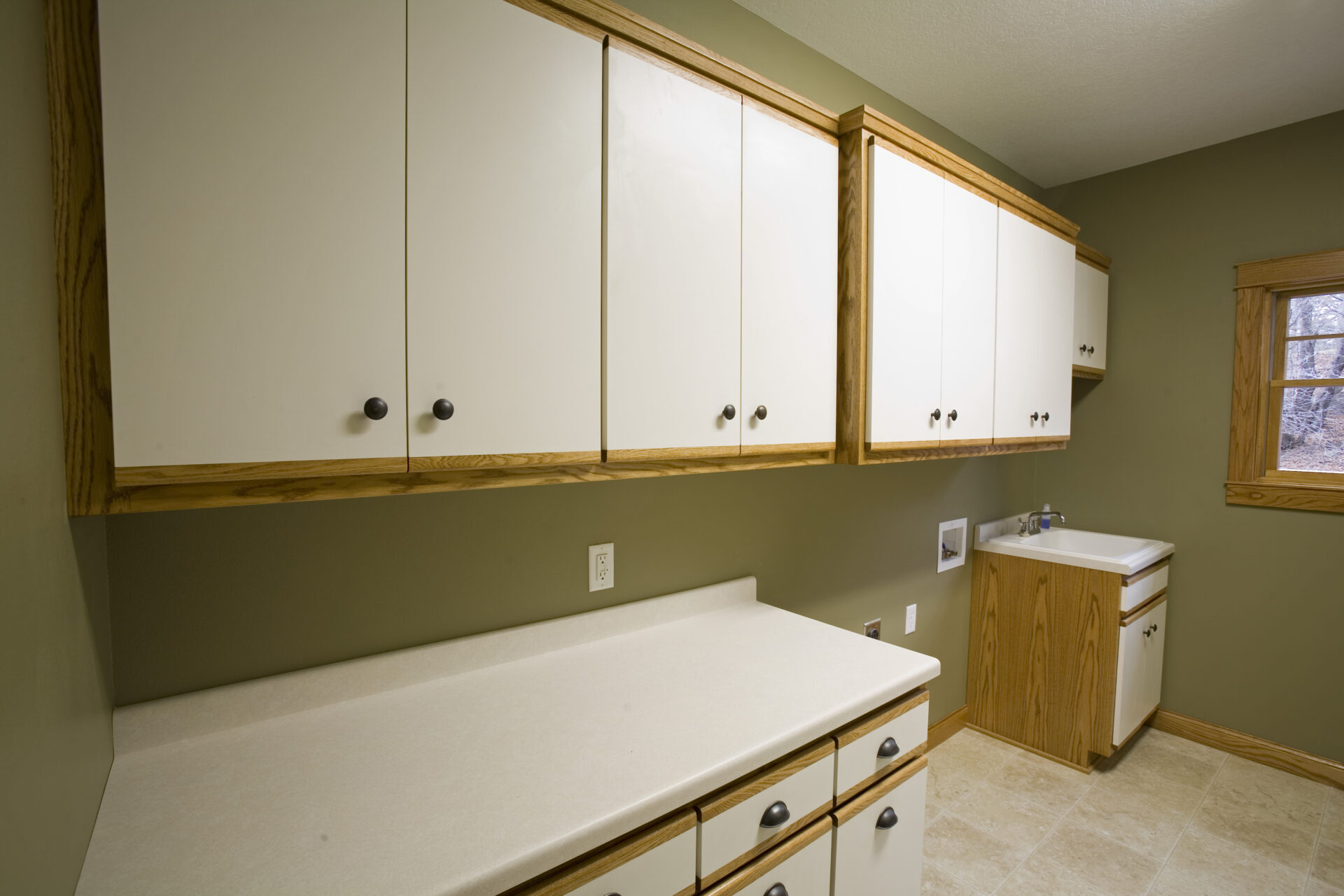 A kitchen with white cabinets and wood trim.