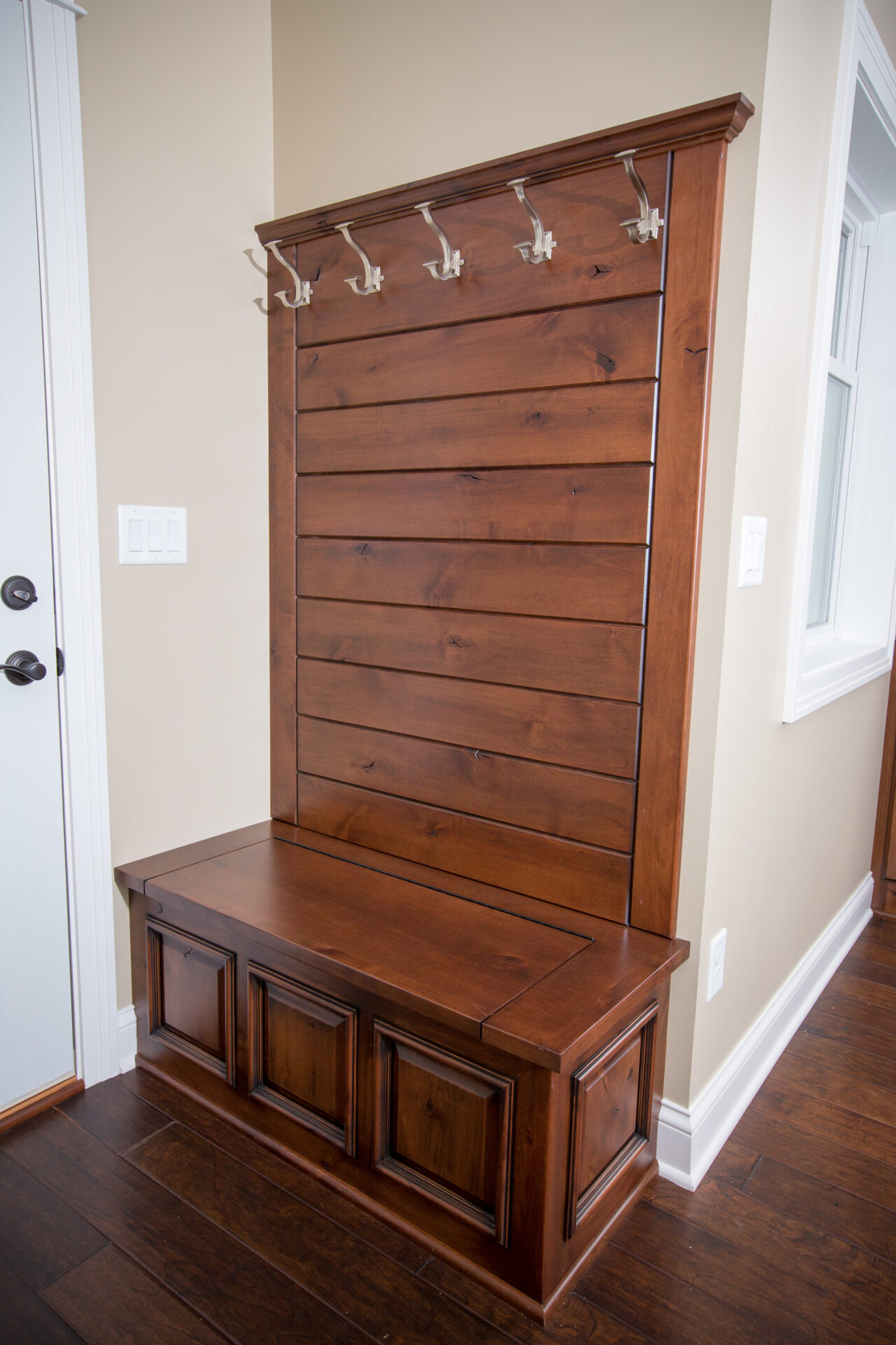 A wooden bench with hooks on the side of it.