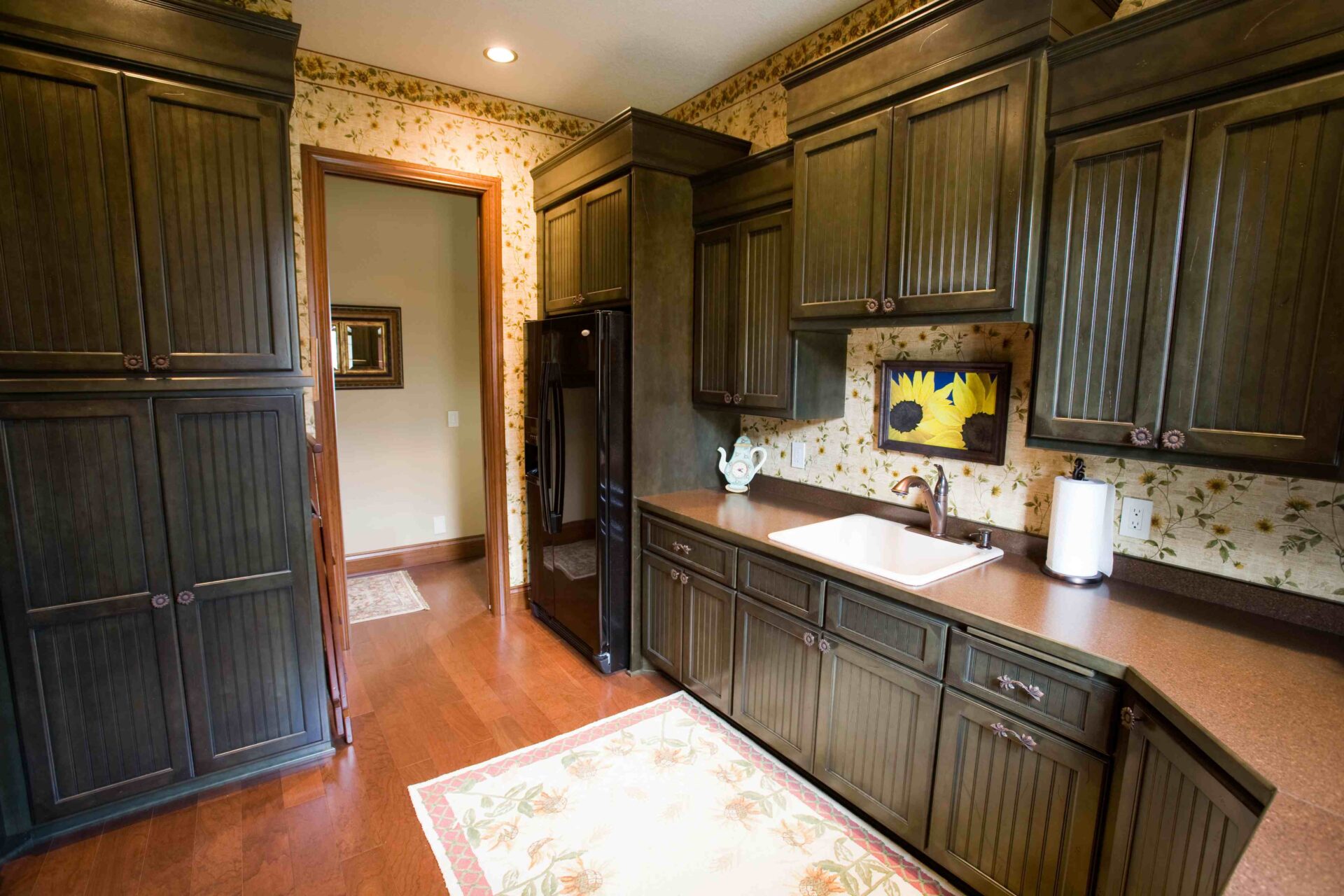 A kitchen with wooden cabinets and floors