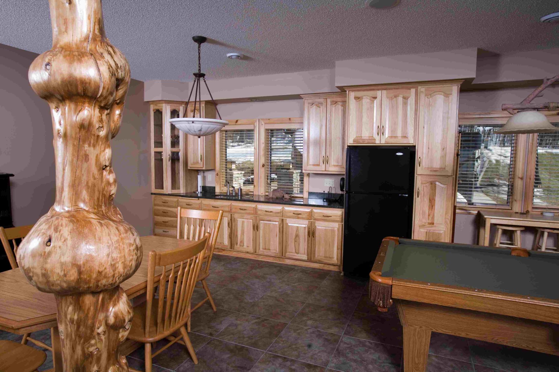 A kitchen with wooden cabinets and black refrigerator.