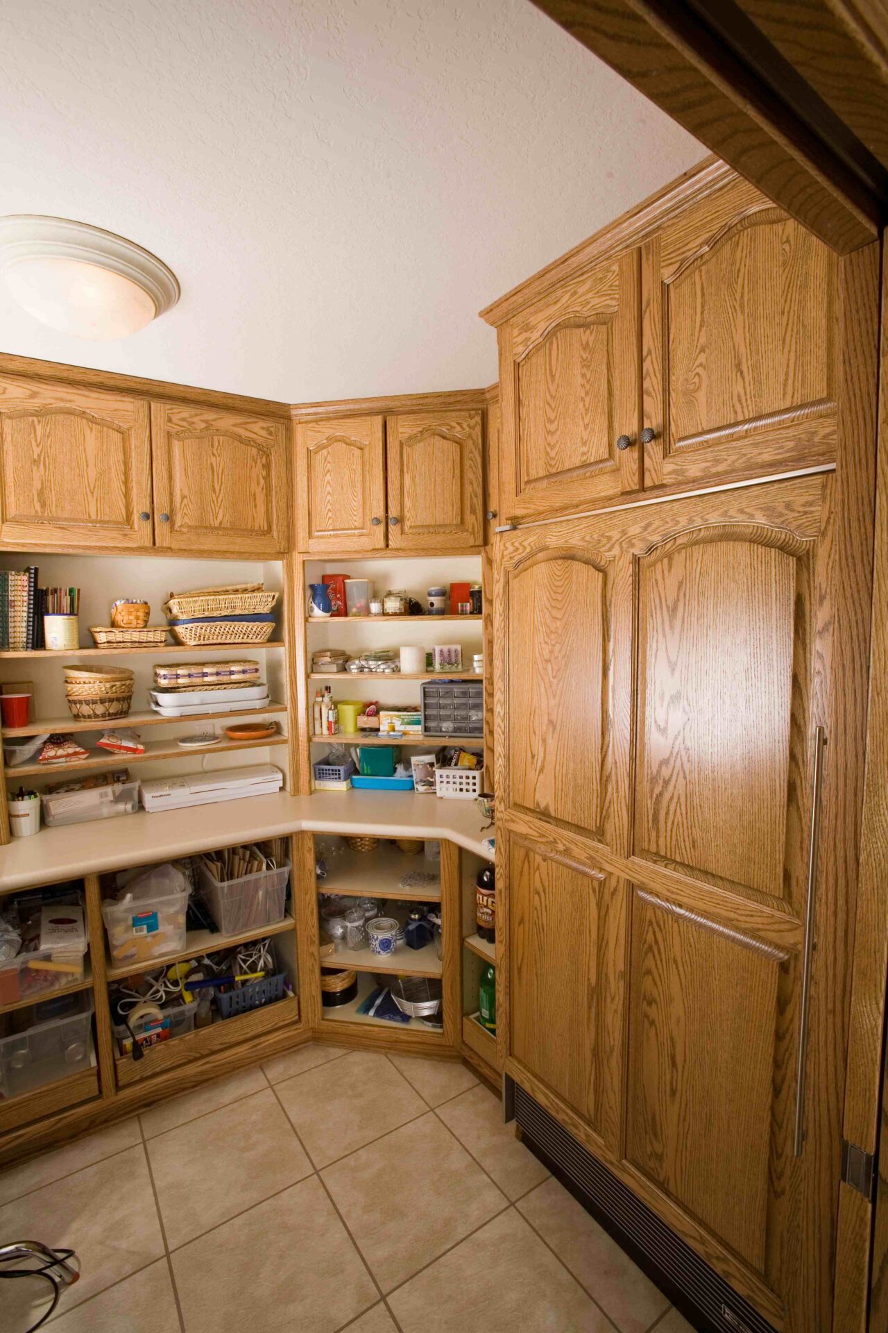 A kitchen with many wooden cabinets and shelves.