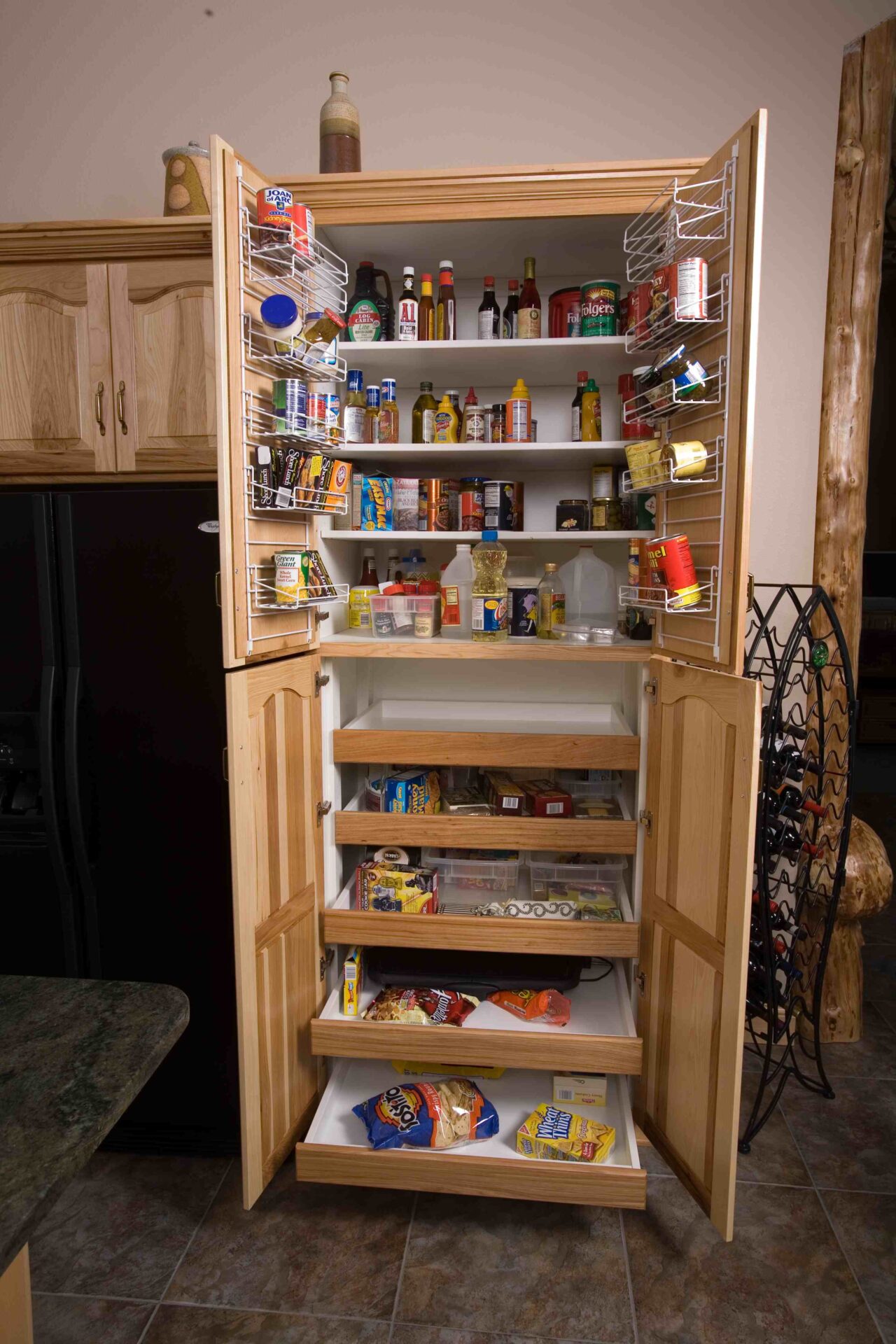 A large wooden cabinet filled with lots of food.