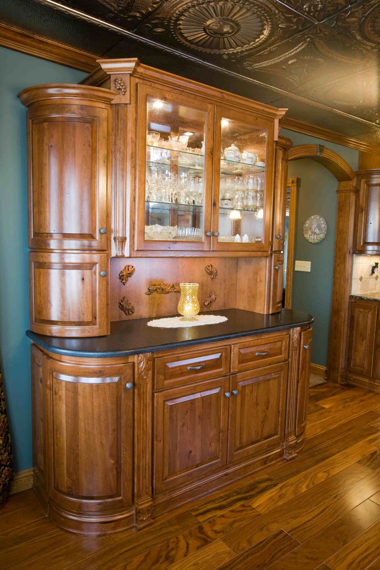 A wooden cabinet with glass doors and a sink.